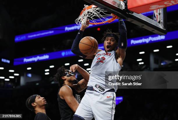 Richaun Holmes of the Washington Wizards reacts after dunking the ball as Nic Claxton of the Brooklyn Nets looks on during the second half at...