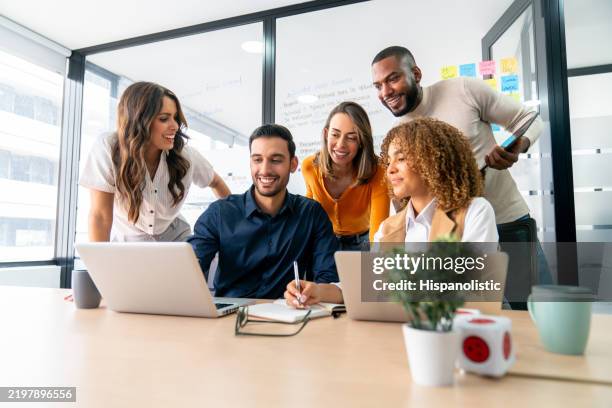 feliz grupo de compañeros de trabajo compartiendo ideas en una reunión de negocios - trabajo en equipo fotografías e imágenes de stock