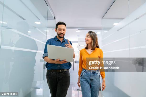 happy coworkers working together at the office using a laptop - colombian people stock pictures, royalty-free photos & images