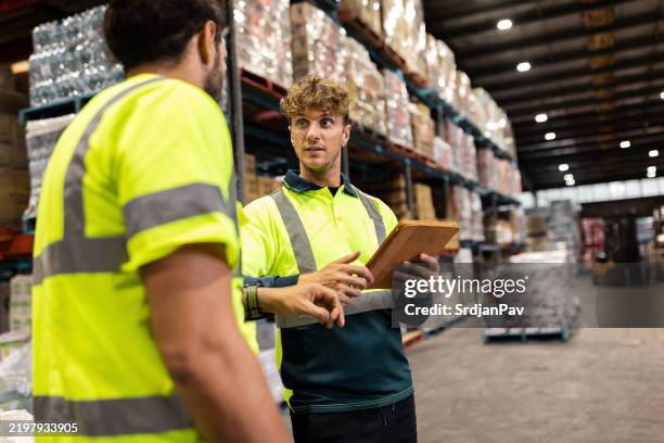 arbeiter arbeiten in einem lager mit einem digitalen tablet für die logistik zusammen - koordination stock-fotos und bilder