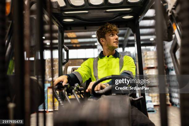 trabajador de almacén que opera una carretilla elevadora en una instalación de almacenamiento - material reflector de seguridad fotografías e imágenes de stock