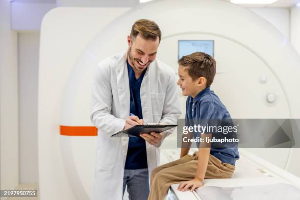 médico amigable que interactúa con un paciente infantil en una instalación médica moderna - tecnología sanitaria fotografías e imágenes de stock