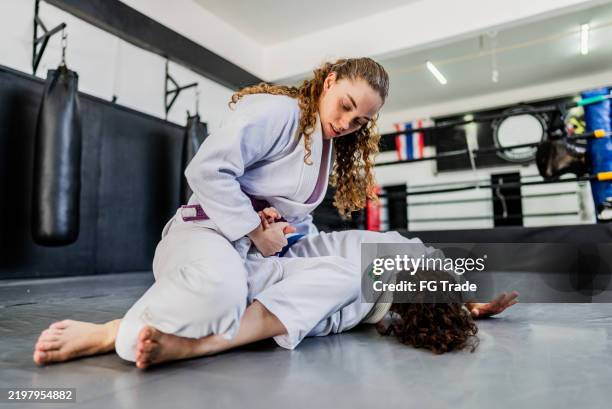 females training jiu-jitsu at the gym - jiu-jitsu stock pictures, royalty-free photos & images