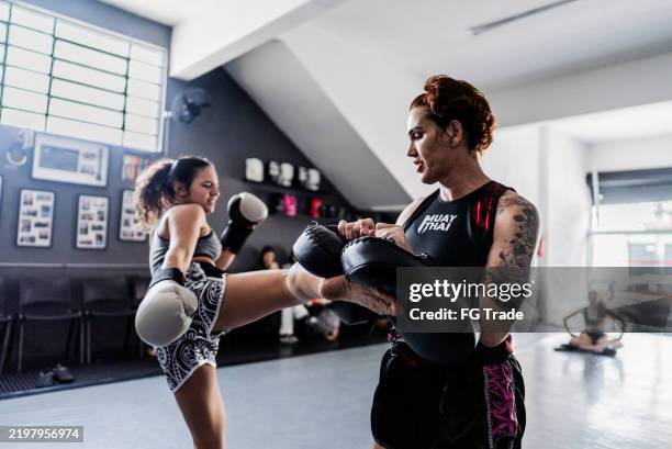 reifer kampftrainer, der einen schüler im fitnessstudio trainiert - kickboxen stock-fotos und bilder
