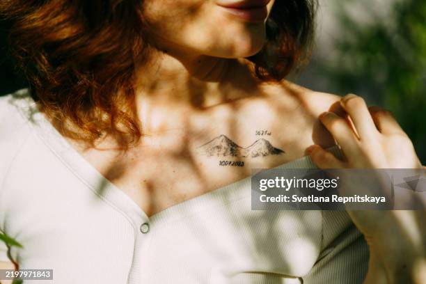 woman displaying mountain tattoo on collarbone - tattoo stock pictures, royalty-free photos & images