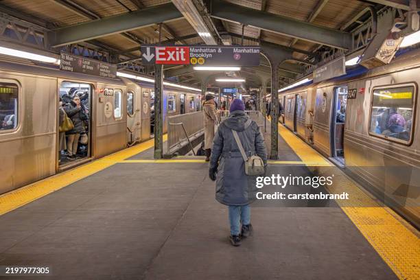 woman walking toward an exit sign at a subway station - train cars stock pictures, royalty-free photos & images