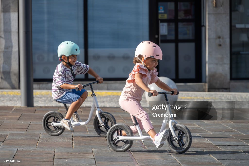 Diverse Children Joyfully Riding Bikes in Urban Setting
