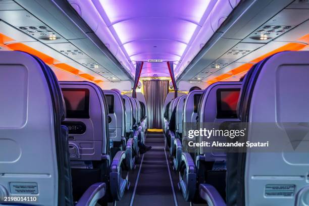 airplane cabin aisle during a night flight - vliegtuigstoel stockfoto's en -beelden