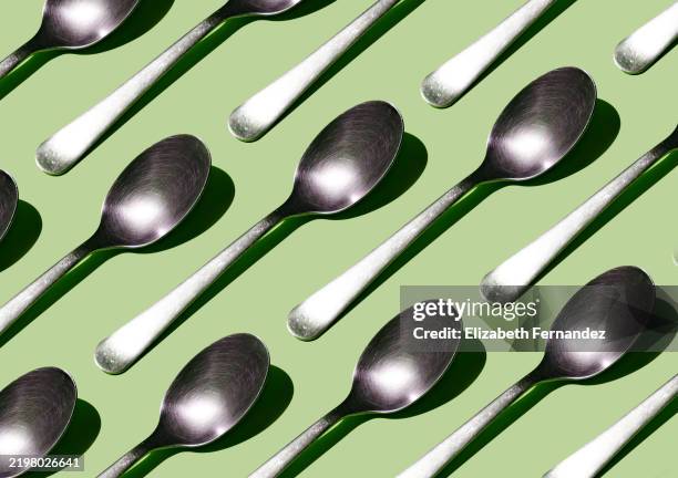 seamless pattern of metal spoons on pistachio green background - rostfritt stål bildbanksfoton och bilder