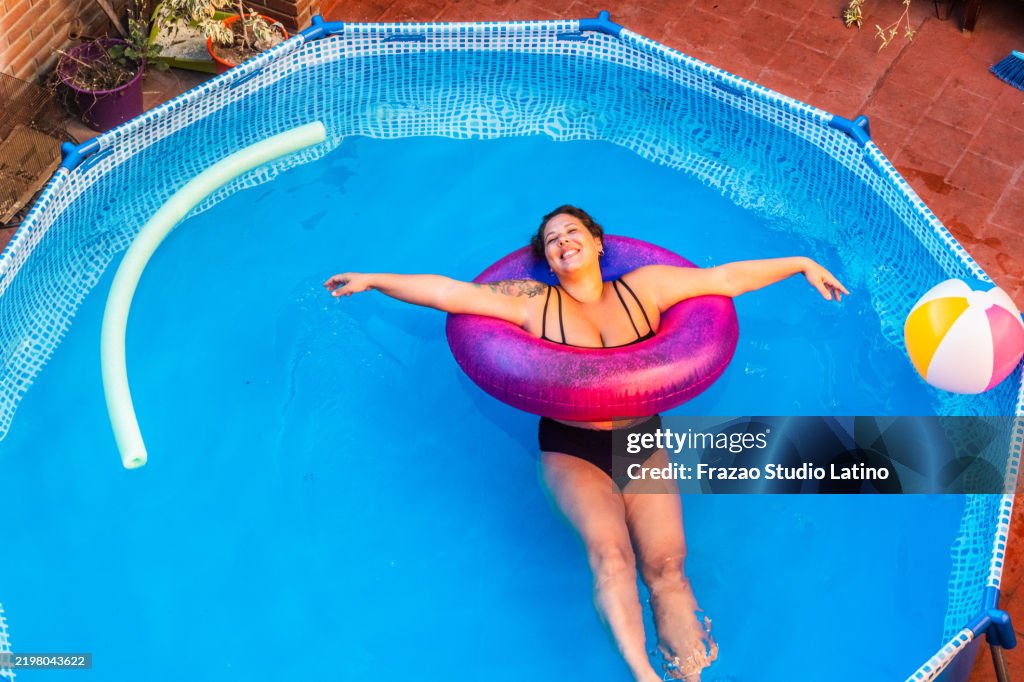 Mid adult woman relaxing in the pool at home
