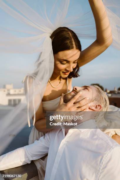 romantic young married couple under veil - veil stock pictures, royalty-free photos & images