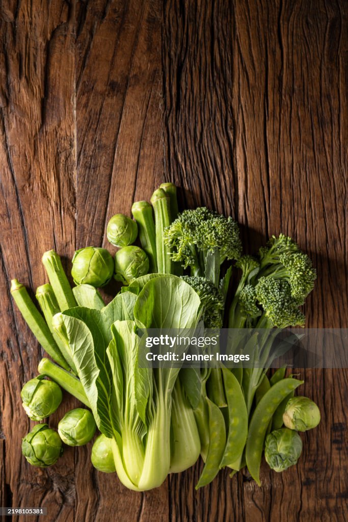 Abundance of fresh green vegetables on a dark wood background. Super food concept.