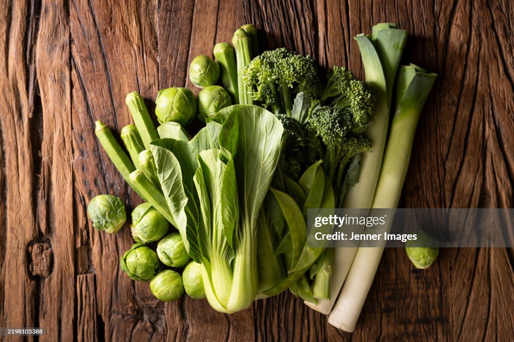 Abundance of fresh green vegetables on a dark wood background. Super food concept.