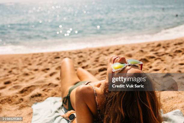 sdraiarsi sulla spiaggia - abbronzarsi foto e immagini stock