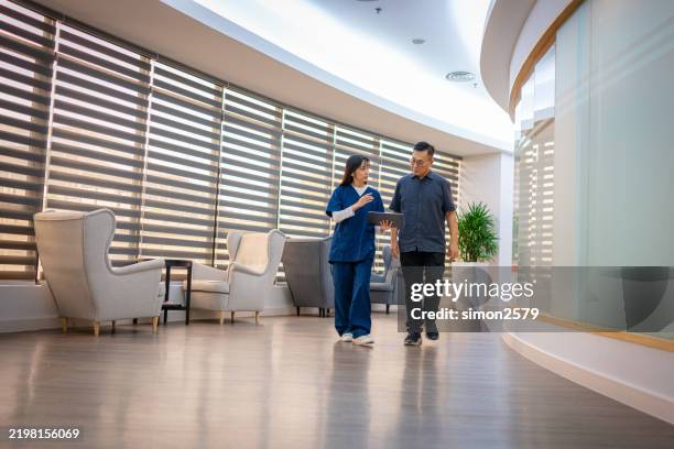 soins de santé en déplacement : données d’examen des médecins et des patients dans le couloir - blouse dexamen médical photos et images de collection