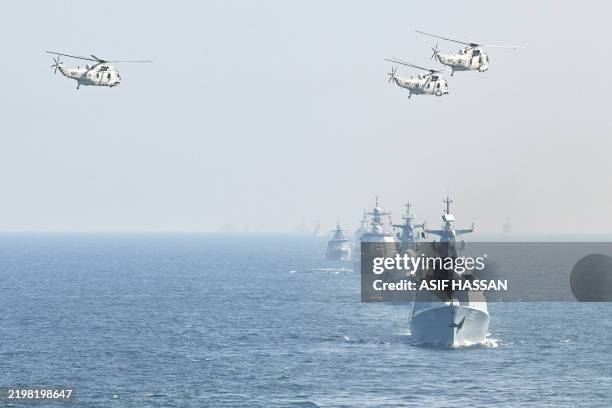 Pakistan's navy Sea King helicopters fly past over Pakistan and others participating countries Naval ships take part during the multinational naval...