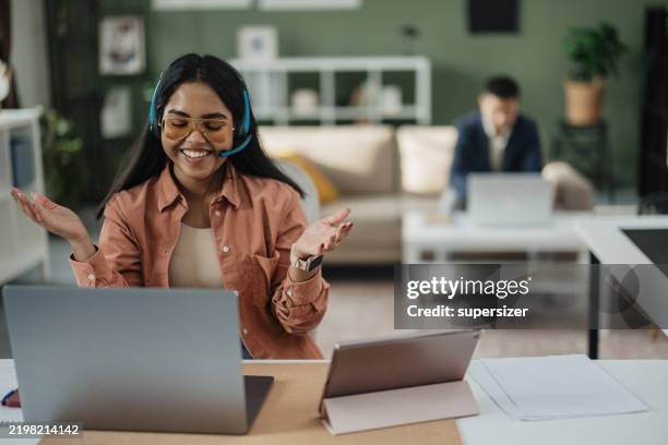 mujer joven alegre gesticulando en la oficina moderna - una sola mujer joven fotografías e imágenes de stock