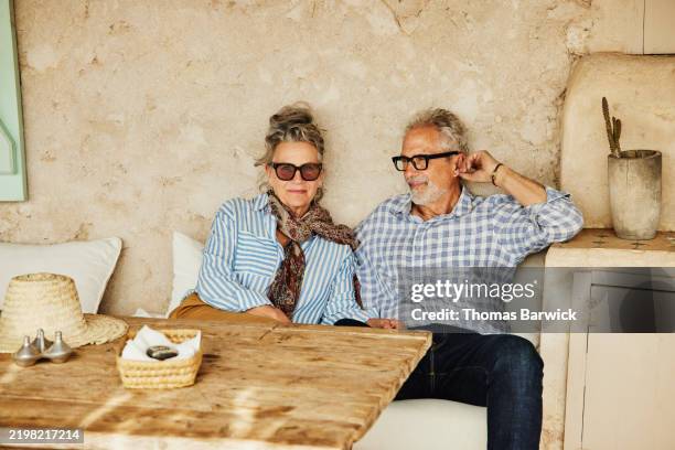 medium wide shot senior couple relaxing at villa during vacation - north africa stock pictures, royalty-free photos & images