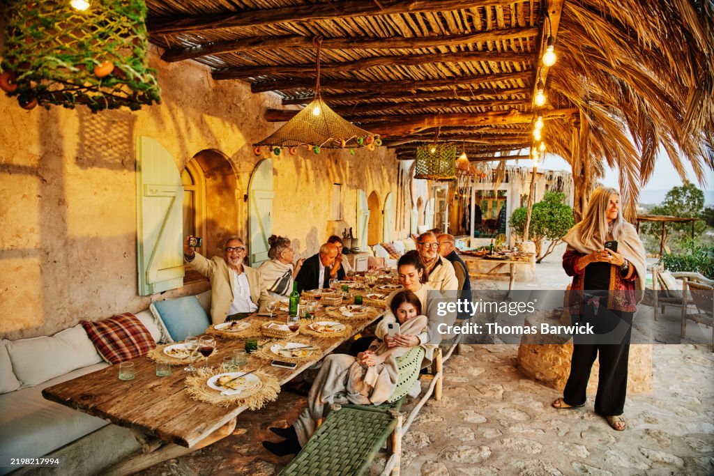 Wide shot friends and family admiring sunset during wedding reception