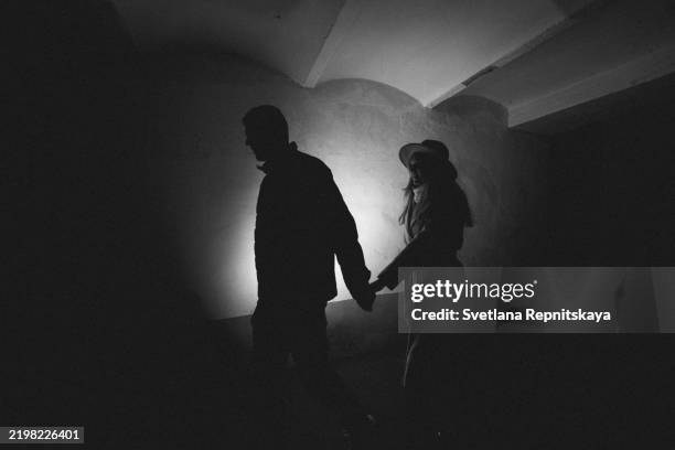 silhouetted couple walking in dark passageway - música cinematográfica fotografías e imágenes de stock