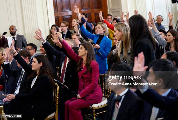 Journalist and CNN news anchor Kaitlan Collins and other journalist raise their hands during a joint press conference between U.S. President Donald...