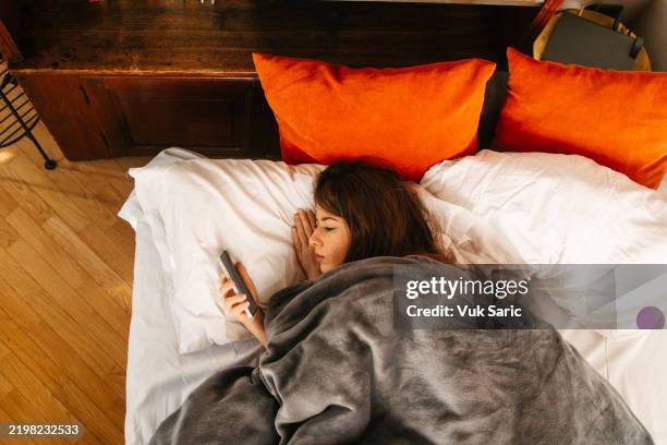 woman staring at her phone in the morning - bed rotting stock pictures, royalty-free photos & images