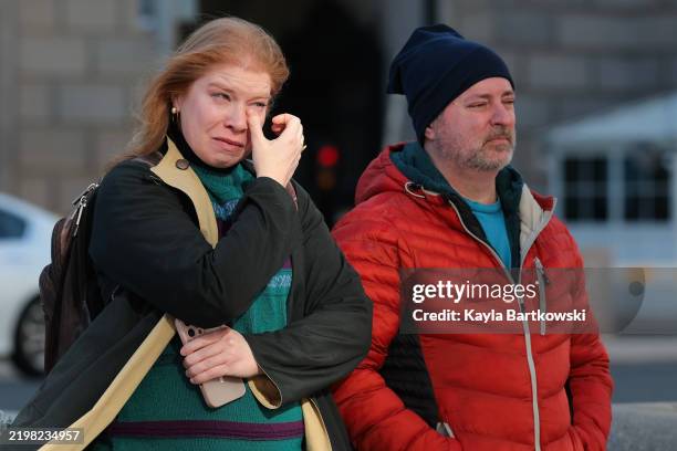 Kristina Dryer , a two-year employee for USAID, wipes away tears after a worker removed the U.S. Agency for International Development sign on their...
