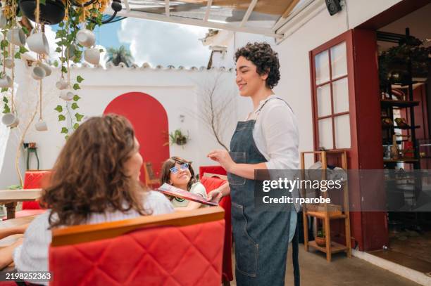 waitress taking order from mother and children at restaurant during the day - family ordering at restaurant stock pictures, royalty-free photos & images