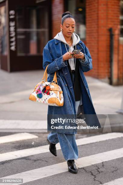 Guest wears silver earrings, light gray cropped hoodie, black oversized blazer jacket, dark navy blue denim jean coat, black leather belt, light blue...