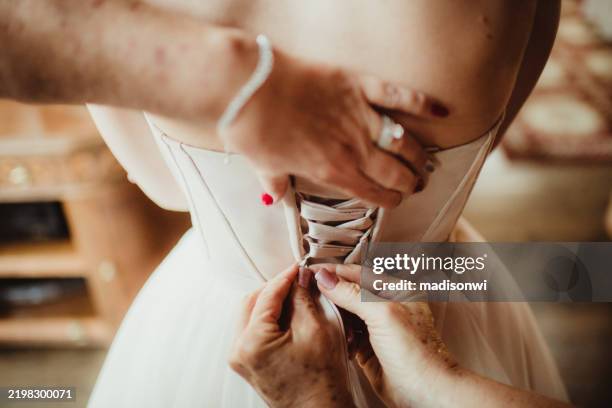 bride getting dressed for wedding ceremony having dress laced up - korsett bildbanksfoton och bilder