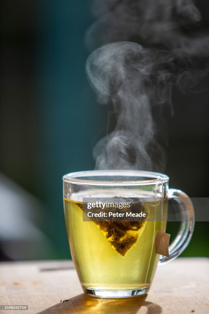 A cup of green tea steaming in the sunlight - superfoods