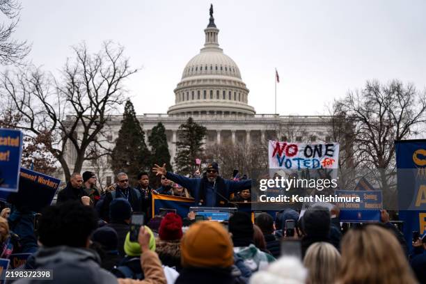 People listen as Everett Kelley, President of the American Federation of Government Employees Union, during a "Save the Civil Service" rally outside...