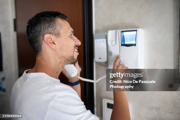 man using an intercom system at home - modern door bell stock pictures, royalty-free photos & images
