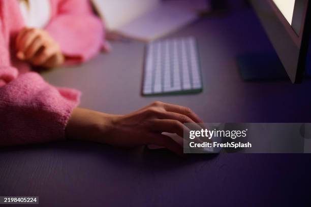 femme utilisant une souris d’ordinateur tard dans la nuit dans un espace de travail faiblement éclairé - souris dordinateur photos et images de collection