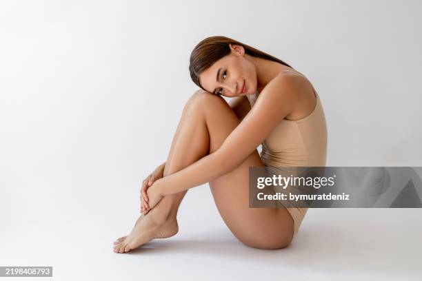 woman in nude colored lingerie sitting - fetal position stock pictures, royalty-free photos & images