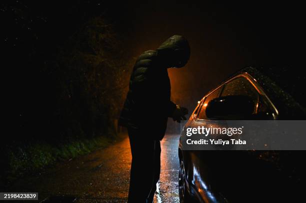 concepto de robo de coche por la noche. - camisa con capucha fotografías e imágenes de stock