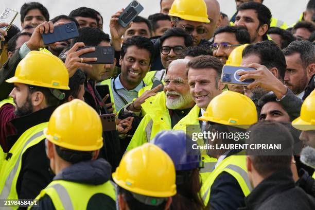 French President Emmanuel Macron and Indian Prime Minister Narendra Modi pose for selfies as they meet with workers during a visit at the ITER in...