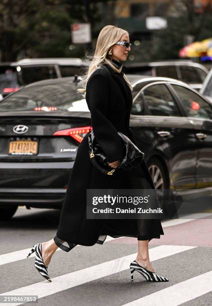Leonie Hanne is seen wearing a black Altuzarra dress, black bag, zebra print heels and sunglasses outside the Altuzarra show during NYFW F/W 2025 on...