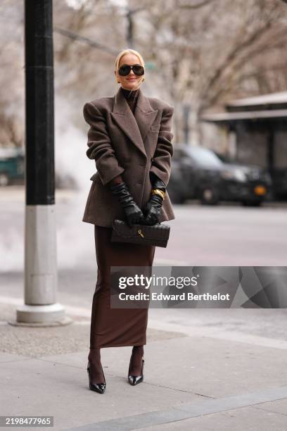 Guest wears black Altuzarra sunglasses, gold earrings, deep dark brown turtleneck long sleeve form fitting midi dress, dark brown oversized double...