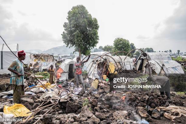 Internally displaced families dismantle their huts before leaving the camp in Bulengo on February 12, 2025. Fighting erupted Tuesday in eastern...