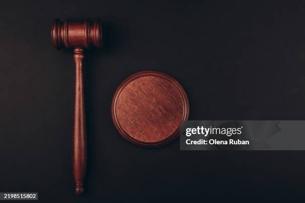 wooden gavel and a sound block on a dark surface. - verurteilung stock-fotos und bilder