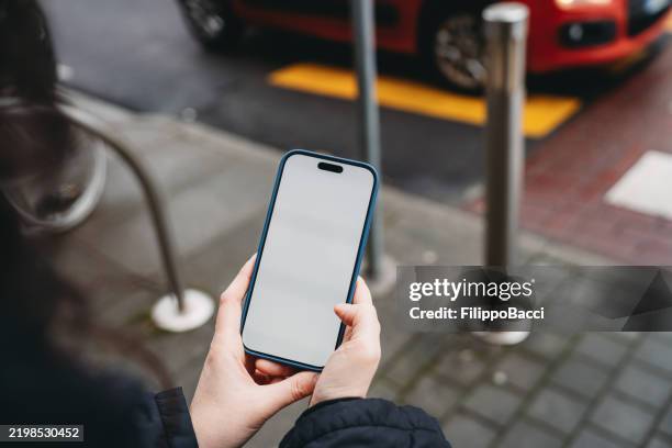 femme utilisant un smartphone avec un écran blanc vide à l’extérieur - écran blanc photos et images de collection