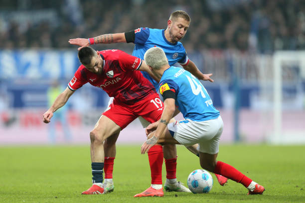 Matus Bero of VfL Bochum battles for possession with Lewis Holtby and John Tolkin of Holstein Kiel during the Bundesliga match between Holstein Kiel...