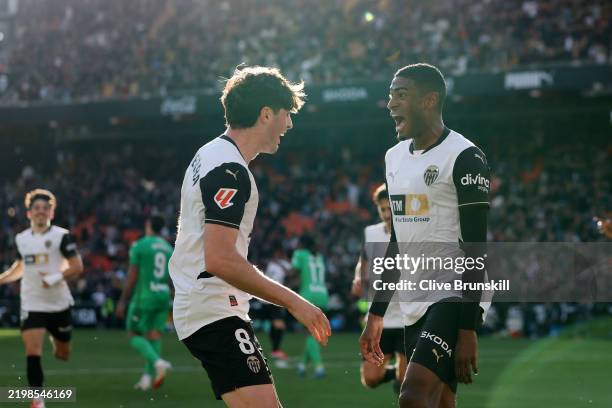 Cristhian Mosquera of Valencia CF celebrates with teammate Javi Guerra after scoring his team's first goal during the LaLiga match between Valencia...