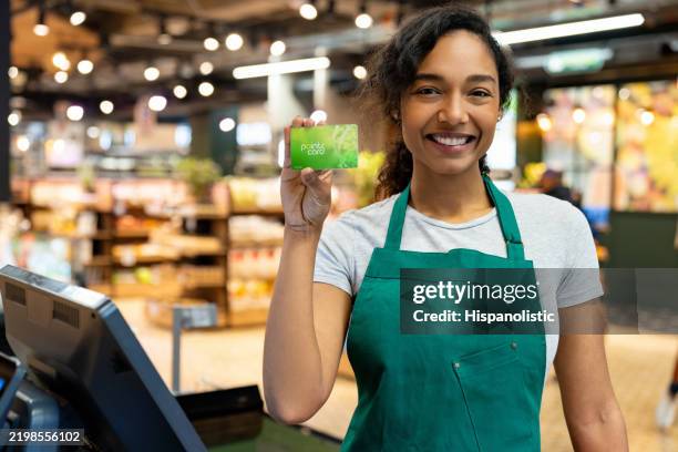 kassiererin mit kundenkarte in einem supermarkt - prämienkarte stock-fotos und bilder