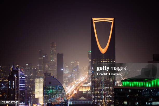 luftaufnahme von riad bei nacht mit beleuchteten modernen wolkenkratzern und belebten straßen unter einem klaren dunklen himmel, al olaya straße - riad stock-fotos und bilder