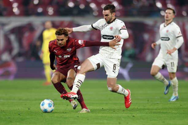 Antonio Nusa of RB Leipzig is challenged by James Sands of FC St. Pauli 1910 during the Bundesliga match between RB Leipzig and FC St. Pauli 1910 at...