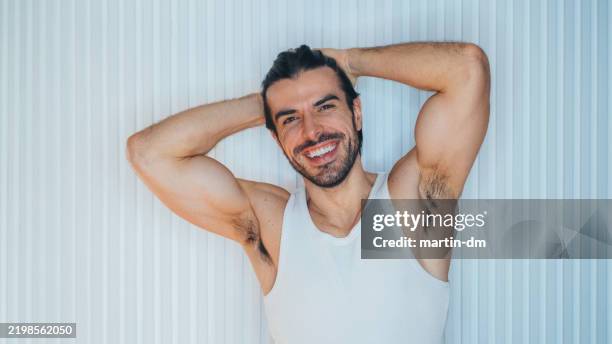 portrait of smiling man at home - unterhemd stock-fotos und bilder