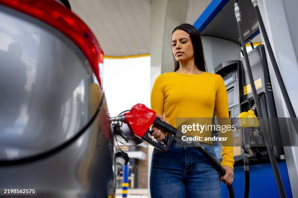 customer refueling her car at a gas station - refueling stock pictures, royalty-free photos & images
