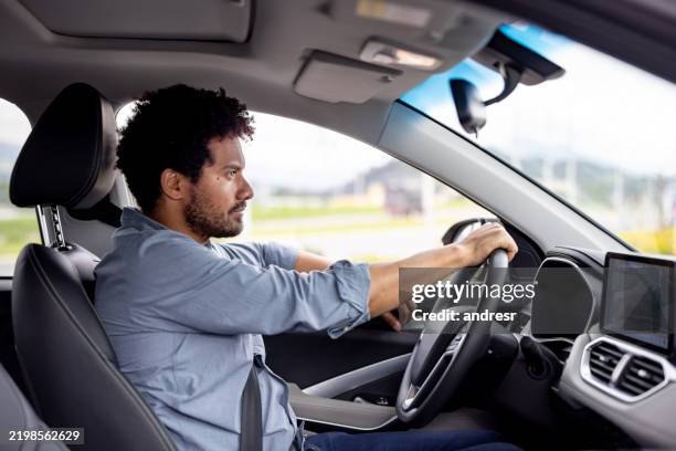 man looking focused driving a car - driving stock pictures, royalty-free photos & images